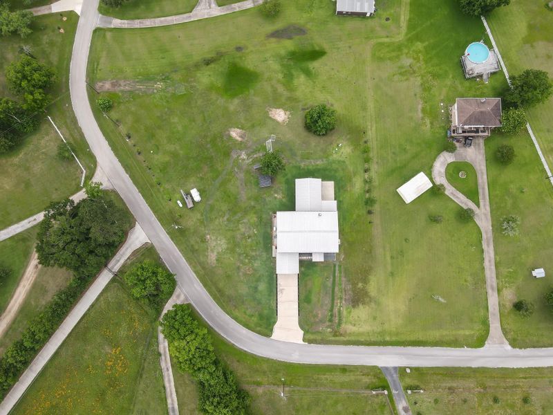 Located on a corner lot, it offers a paved driveway and easy access from the road, with ample open space for outdoor activities or future expansion.