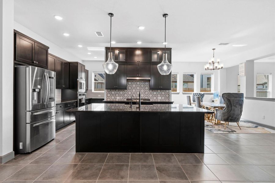 Stunning kitchen layout with expansive island, abundant storage, and seamless flow to dining area.