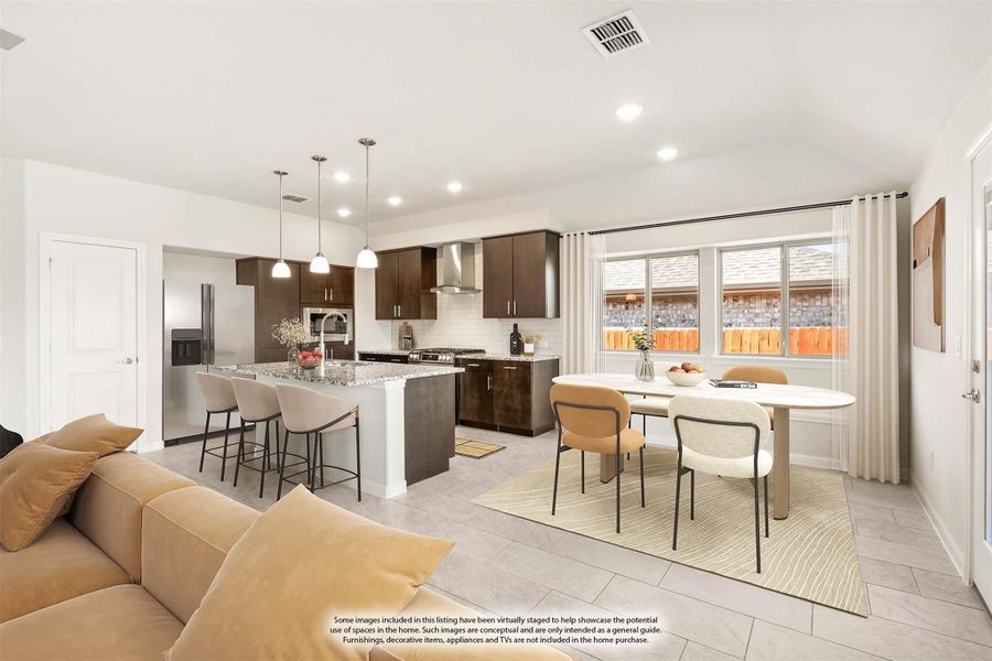 Open-concept living area with kitchen island, dark wood cabinets, dining table, and tile floors