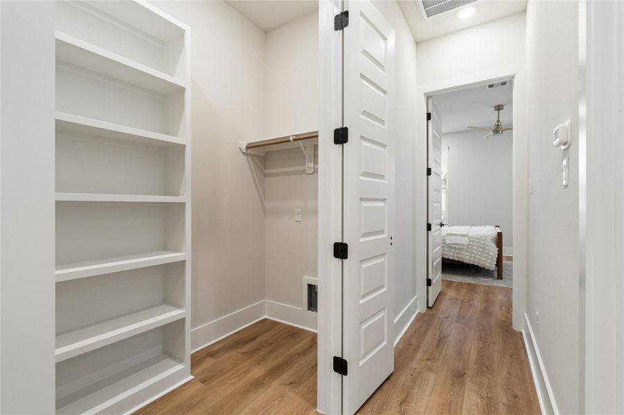 Utility room with built-in shelving, offering added storage for everyday organization. Utility room with built-in shelving, offering added storage for everyday organization.