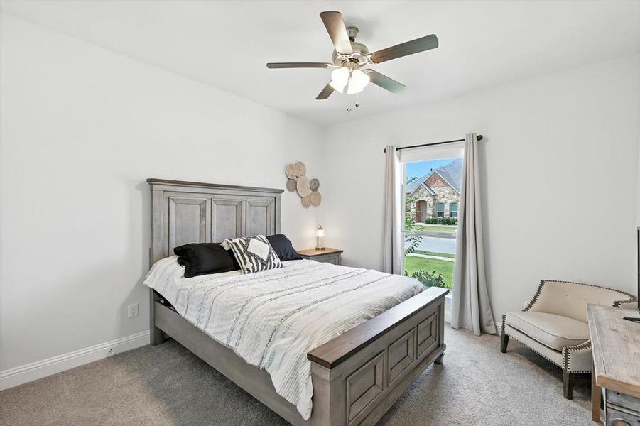 Bedroom with light carpet and a ceiling fan