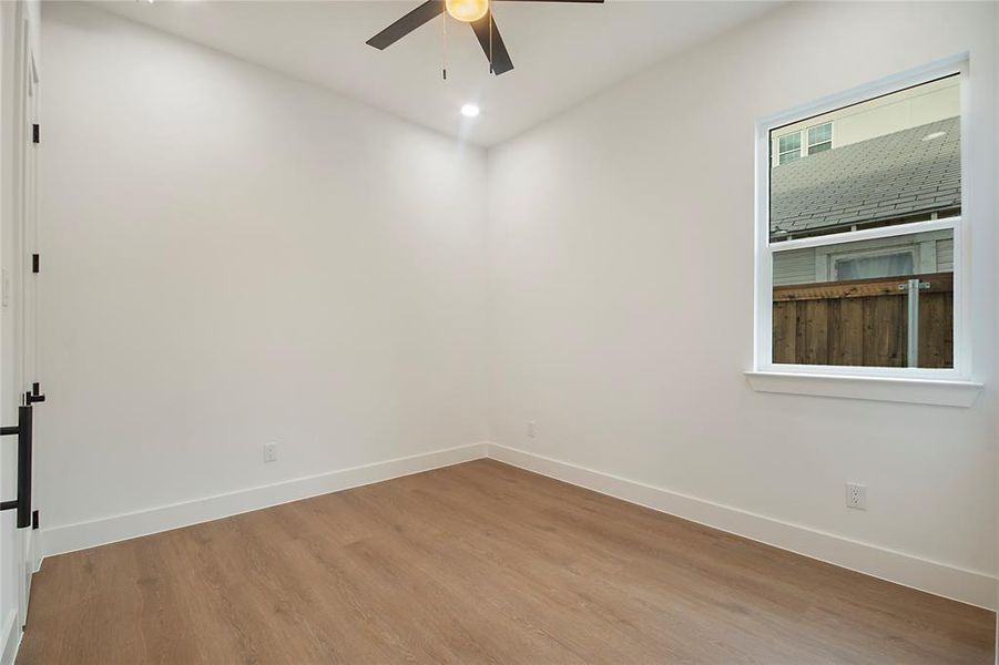 Empty room featuring wood finished floors, a ceiling fan, and recessed lighting