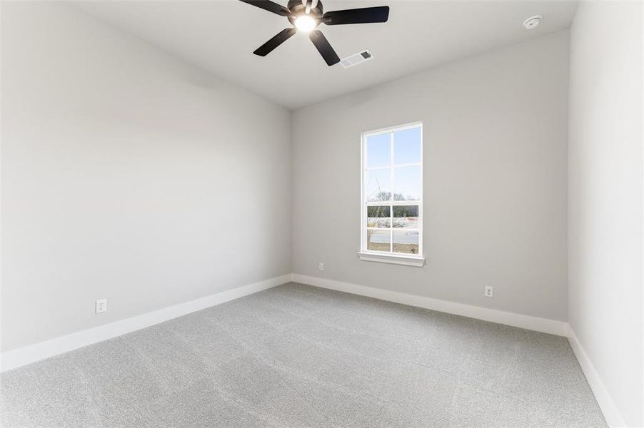 Empty room featuring carpet and a ceiling fan