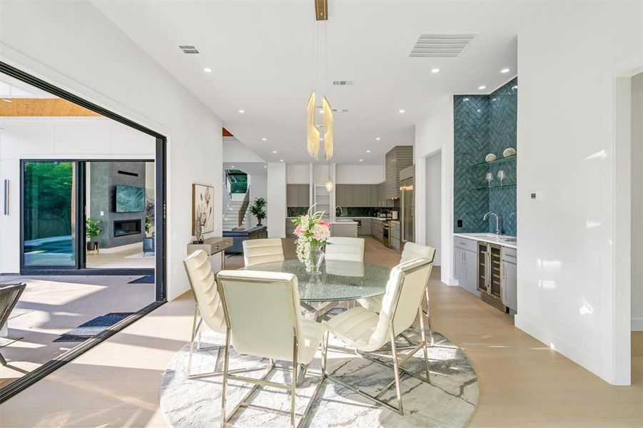 Dining room with wet bar, wine cooler, recessed lighting, and light wood-type flooring