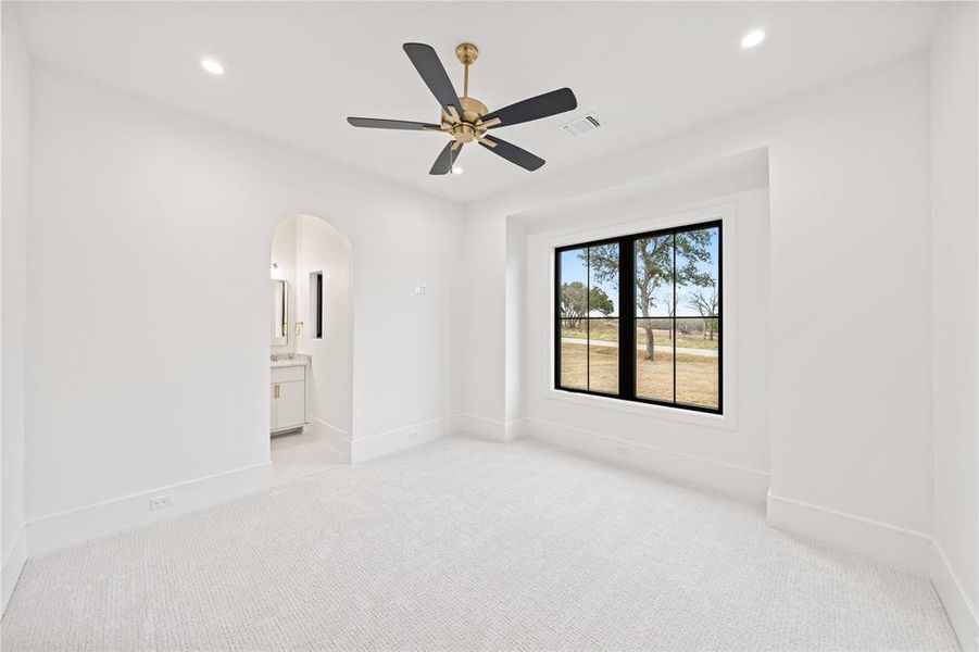Bright room featuring white walls, recessed lighting, and a modern ceiling fan with a gold-tone base and black blades