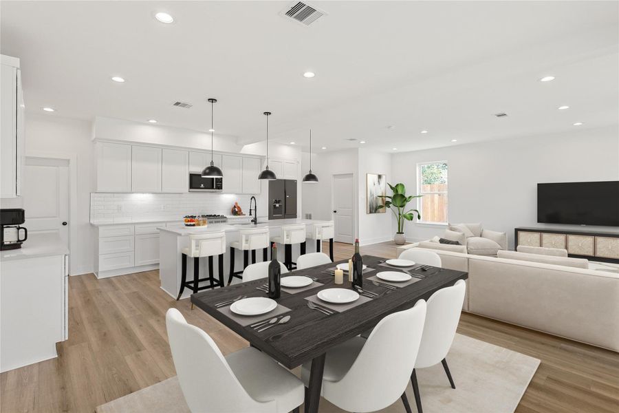 View of the modern kitchen from the dining room, showcasing stainless steel appliances, a spacious pantry, a large island with quartz countertops, and abundant natural light from surrounding windows. Photo is virtually staged.
