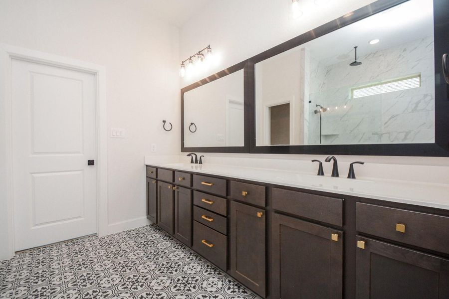 The dual-sink vanity offers generous counter space, abundant storage, and contemporary finishes, creating a bright and functional space for your daily routine. Seamlessly connected to the primary bedroom, this well-appointed bathroom enhances the comfort and convenience of the private owner's suite.