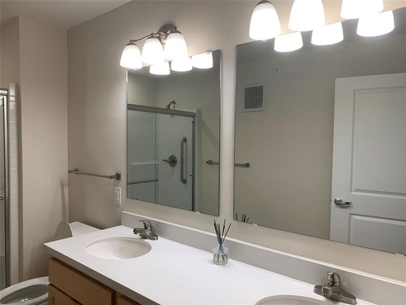 Bathroom with a stall shower and double vanity