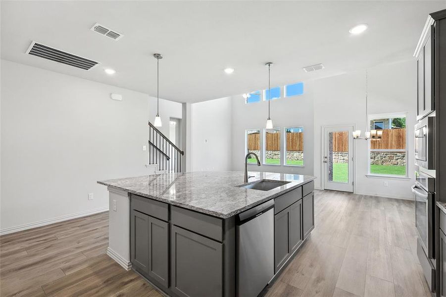 Kitchen featuring stainless steel appliances, gray cabinetry, an island with sink, plenty of natural light, and recessed lighting Kitchen featuring stainless steel appliances, gray cabinetry, an island with sink, plenty of natural light, and recessed lighting