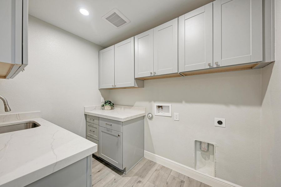 Laundry area featuring light wood finished floors, washer hookup, hookup for an electric dryer, hookup for a gas dryer, and recessed lighting