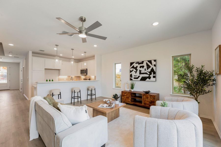 Living room featuring light wood-style flooring, ceiling fan, and recessed lighting