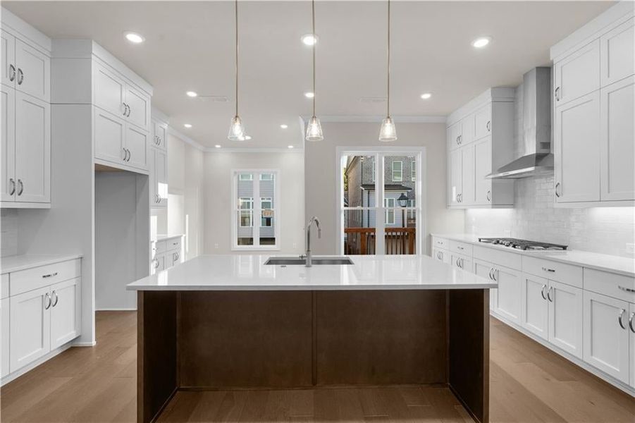 Kitchen with backsplash, white cabinetry, light stone counters, ornamental molding, and recessed lighting