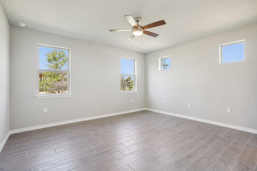 Unfurnished room featuring wood finish floors and a ceiling fan