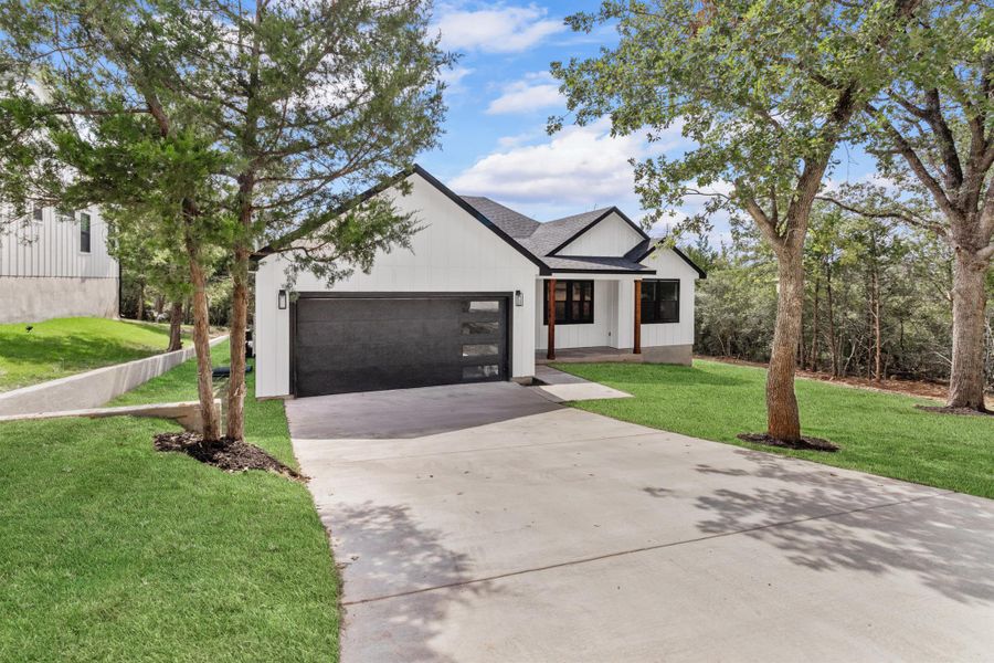 Modern farmhouse style home with driveway, roof with shingles, a front lawn, and an attached garage
