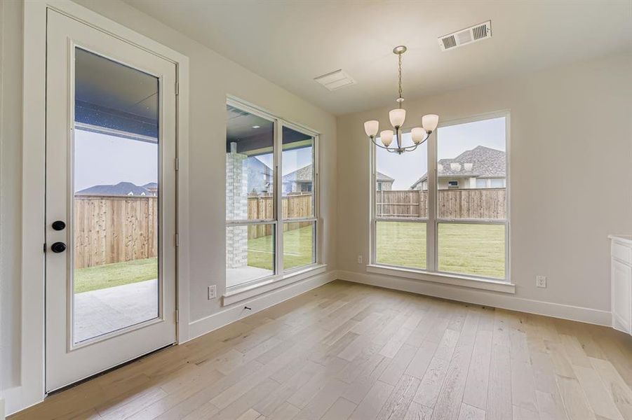 Unfurnished dining area with light wood-style floors and a chandelier