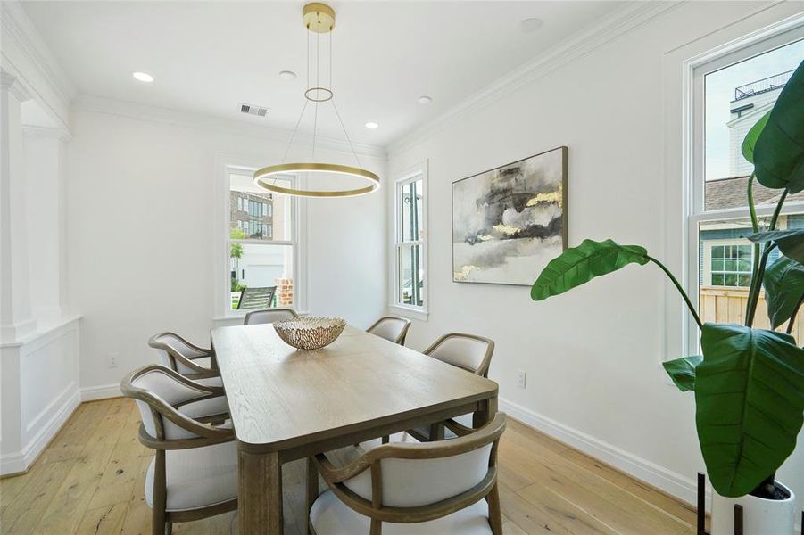 Wide plank white oak hardword floors, a modern circular light fixture, and large windows letting in natural light.