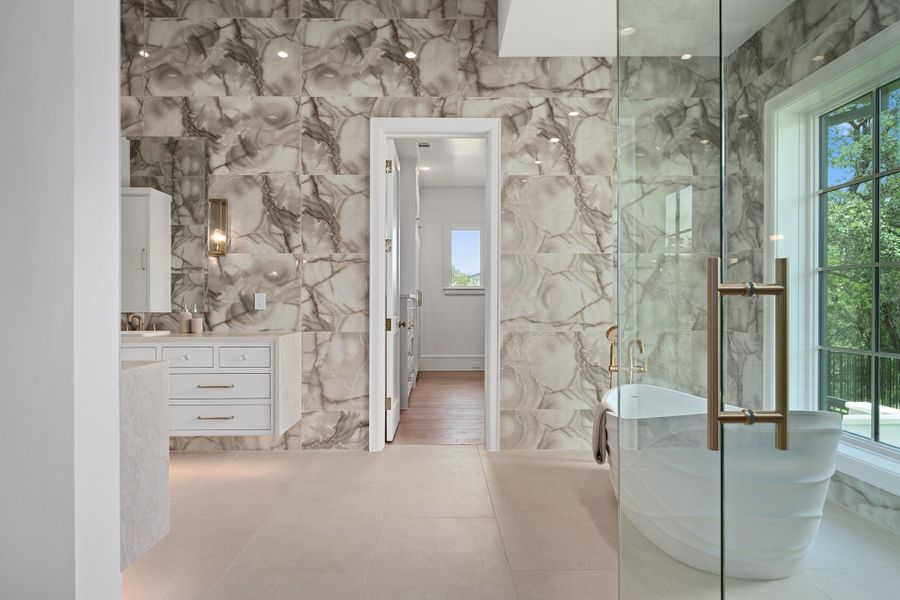 Indulge in this bathroom sanctuary, featuring sleek vanities and a deep soaking tub for ultimate relaxation.