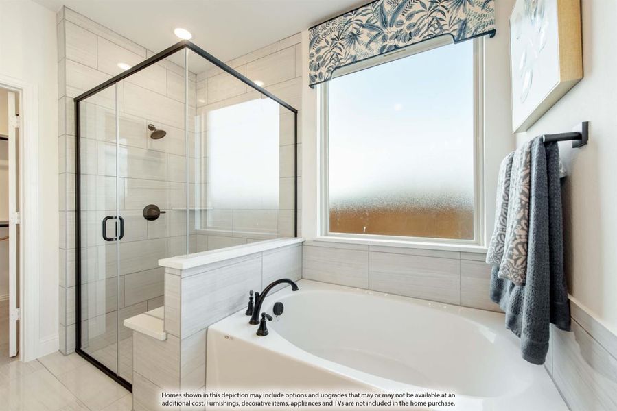 Master bathroom with soaking tub, glass-enclosed shower, gray tile walls, and a frosted window above the tub.