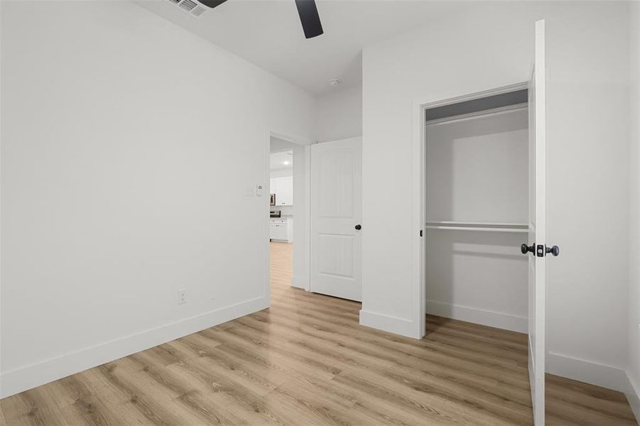 Unfurnished bedroom with ceiling fan, a closet, and light wood-type flooring