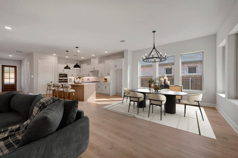 Dining area with light wood-style floors and suspended lighting