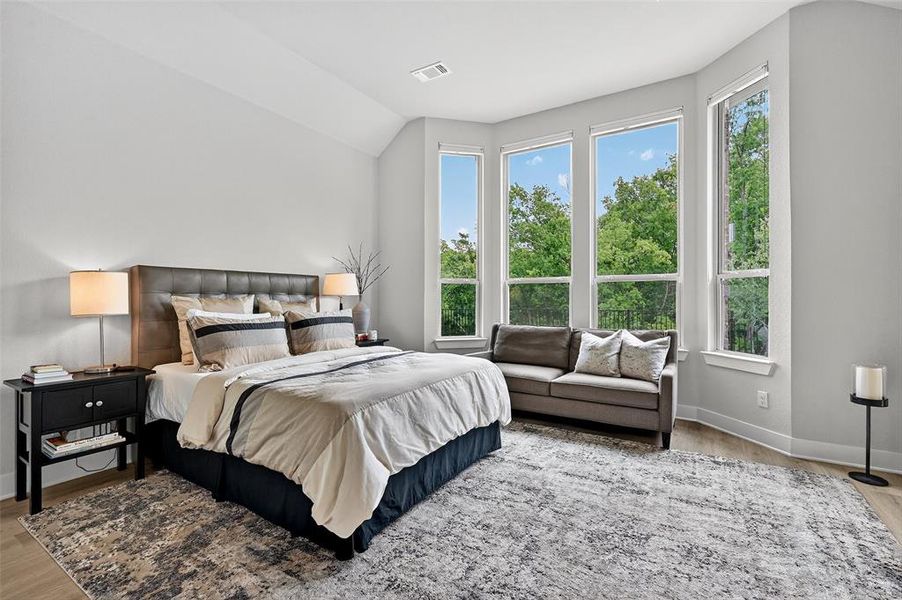 Bedroom featuring wood finished floors and lofted ceiling Bedroom featuring wood finished floors and lofted ceiling