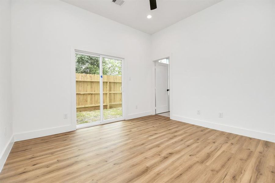 A cozy secondary bedroom featuring a large french door that floods the space with natural light, enhancing the room's airy feel. The spacious closets offer ample storage for all your needs. The neutral color palette creates a serene and inviting atmosphere, perfect for relaxation.