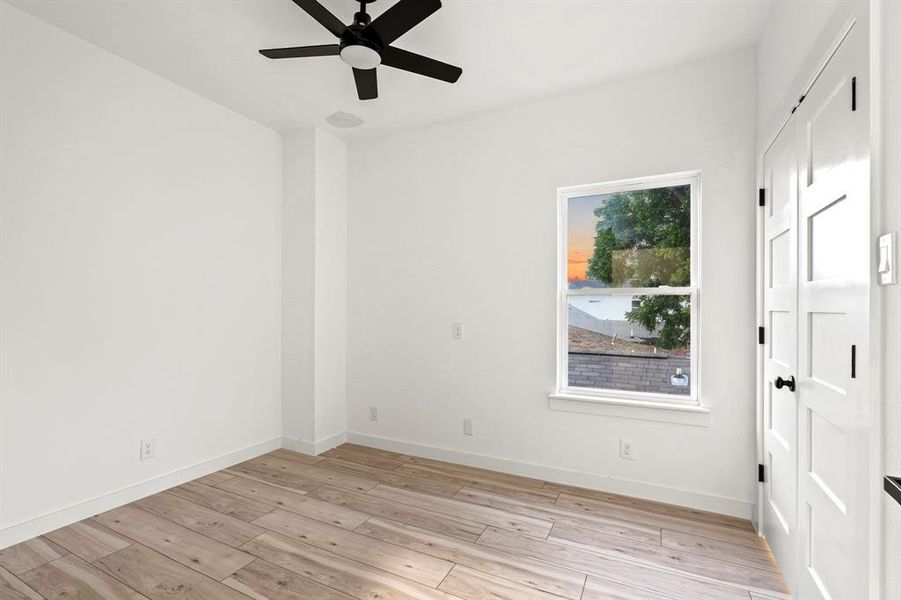 Unfurnished bedroom with light wood-style floors, baseboards, and ceiling fan Unfurnished bedroom with light wood-style floors, baseboards, and ceiling fan