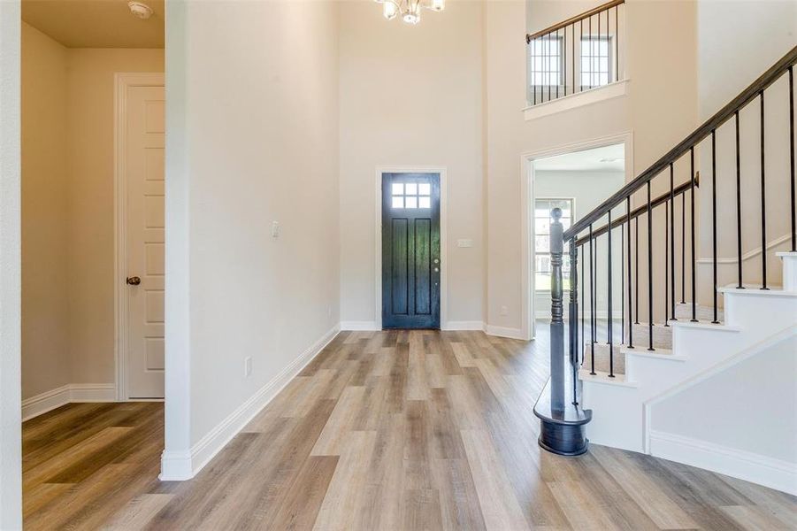 Foyer featuring a notable chandelier, a high ceiling, and light hardwood / wood-style floors