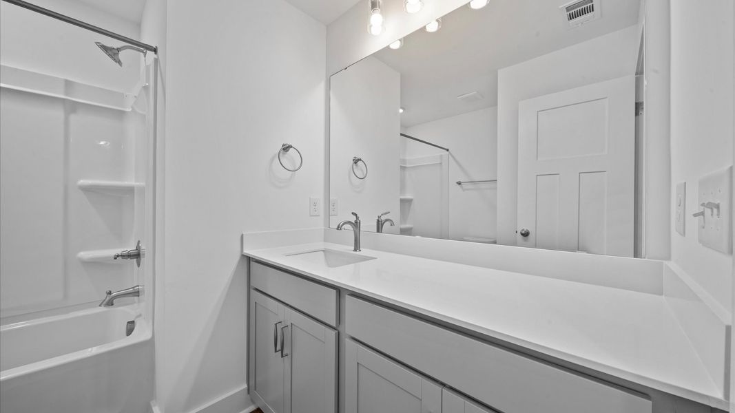 Bathroom with extended countertop vanity in two story townhome at Ransdell Pointe by DRB Homes in Spartanburg, SC
