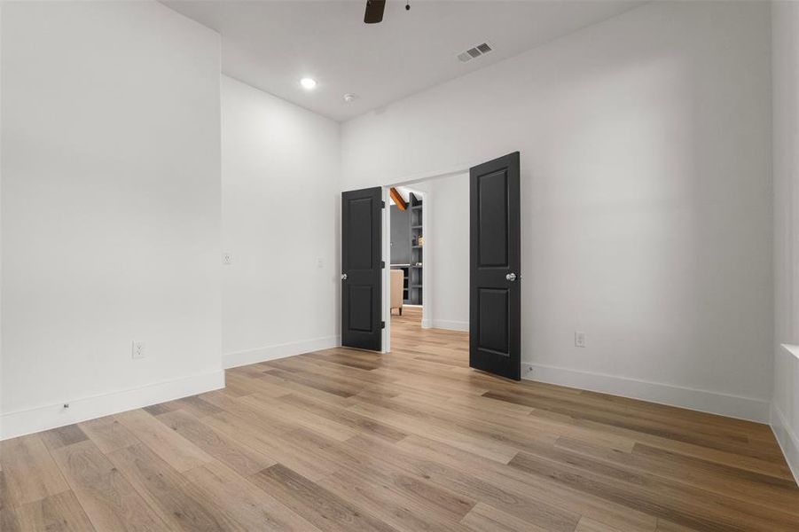 Empty room featuring light wood finished floors, a ceiling fan, and recessed lighting