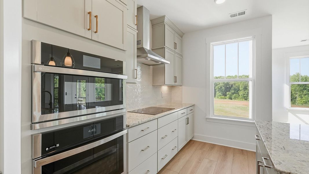 Superior craftsmanship shines in this modern kitchen with stainless appliances and an open flow located at Pinebrook