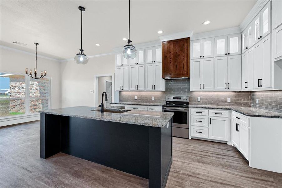 Kitchen featuring sink, light hardwood / wood-style flooring, white cabinets, and electric range