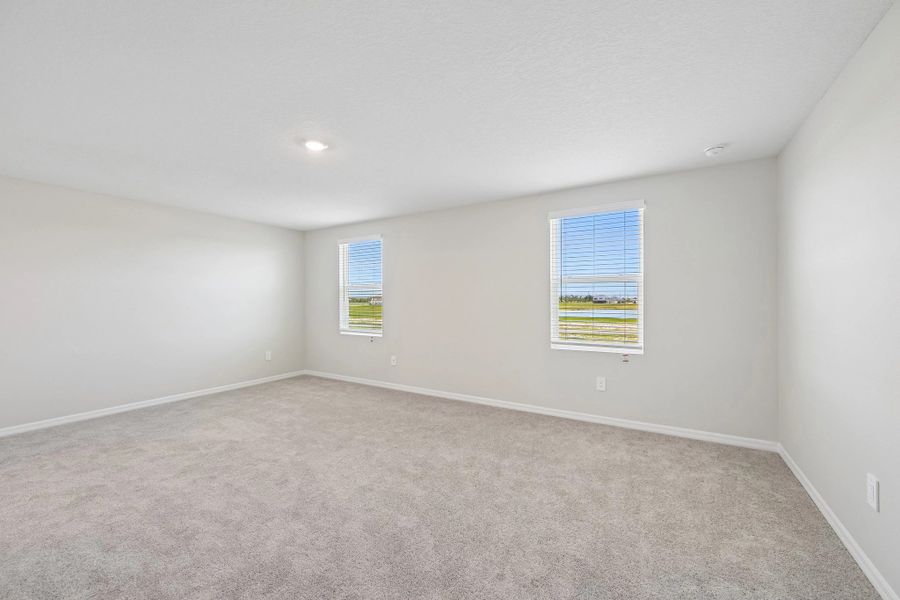 The primary bedroom features two large windows