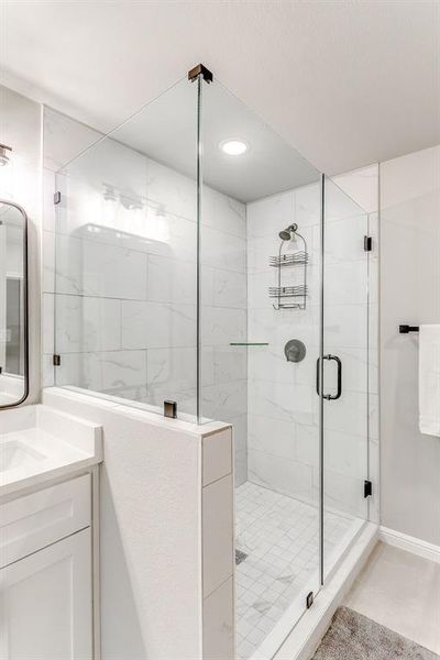 Bathroom with tile patterned flooring, vanity, and an enclosed shower