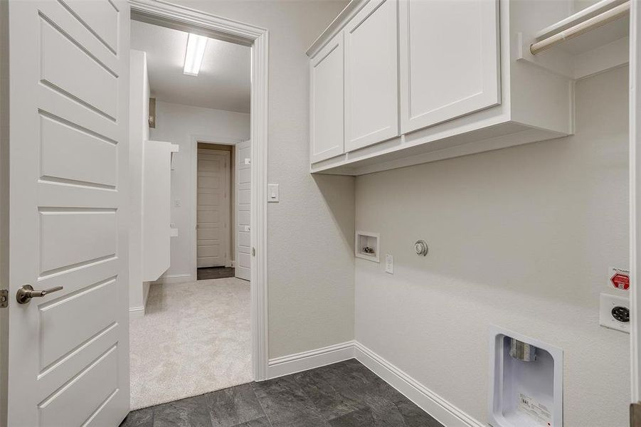 Clothes washing area featuring cabinets, washer hookup, hookup for a gas dryer, and electric dryer hookup