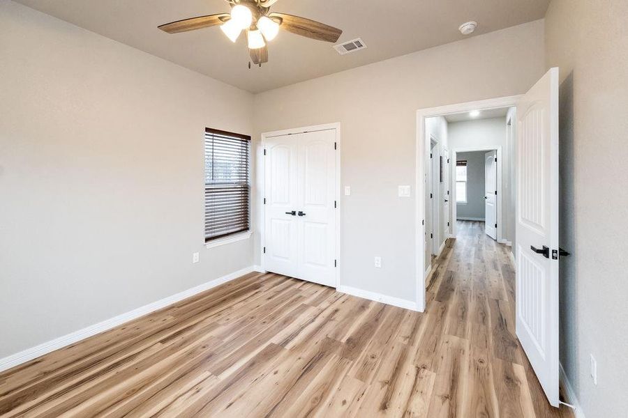 Unfurnished bedroom with a closet, ceiling fan, and light wood-type flooring