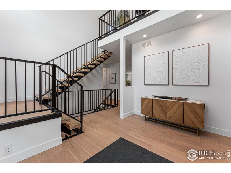 Grand entrance; 22-foot ceilings, White oak flooring, floating staircase, and storage closet