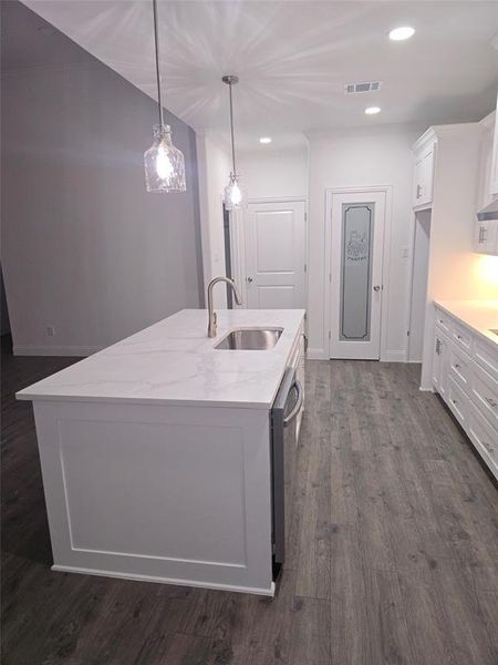 Kitchen featuring white cabinetry, recessed lighting, pendant lighting, dark wood-style floors, and light stone countertops Kitchen featuring white cabinetry, recessed lighting, pendant lighting, dark wood-style floors, and light stone countertops