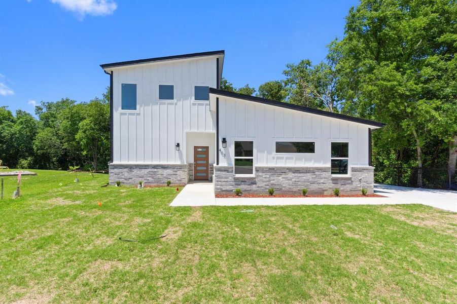 Contemporary home featuring board and batten siding and brick siding Contemporary home featuring board and batten siding and brick siding