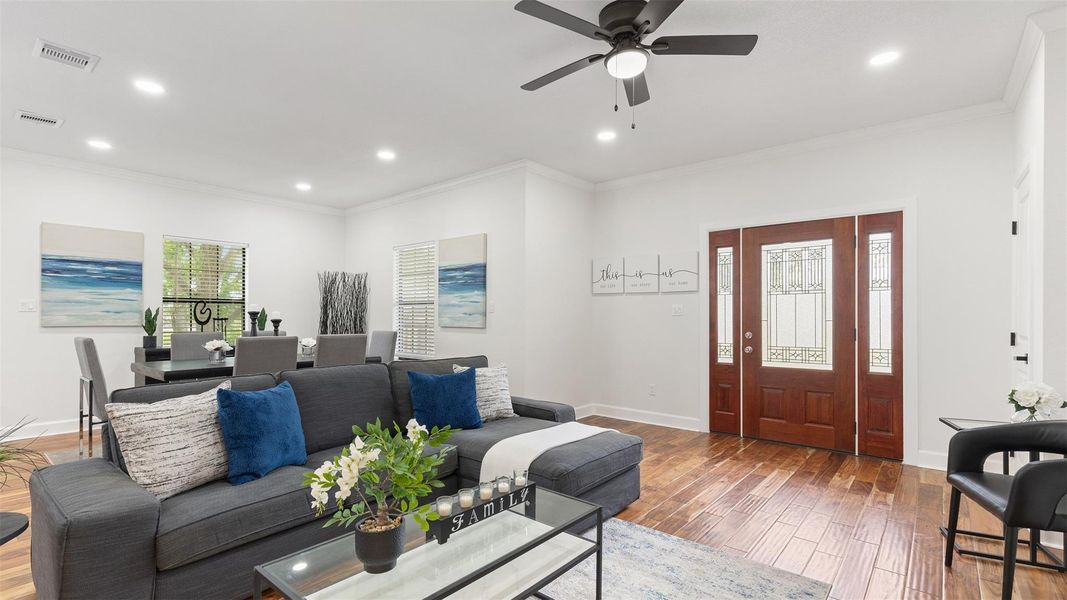The living and dining area features wood-floors, neutral tones, and abundant natural light. The open layout is perfect for both relaxing and entertaining.