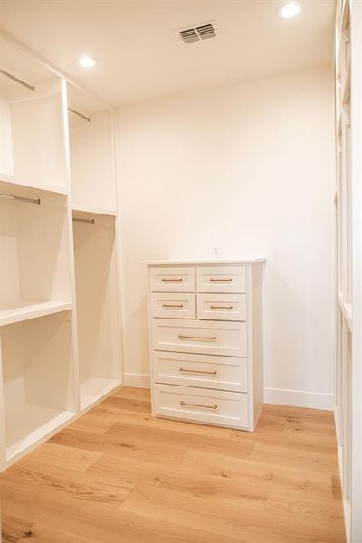 Walk in closet featuring light wood-type flooring Walk in closet featuring light wood-type flooring