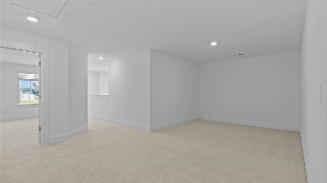 Vibrant carpeted loft offering flexibility as a study nook, game room, or second family space