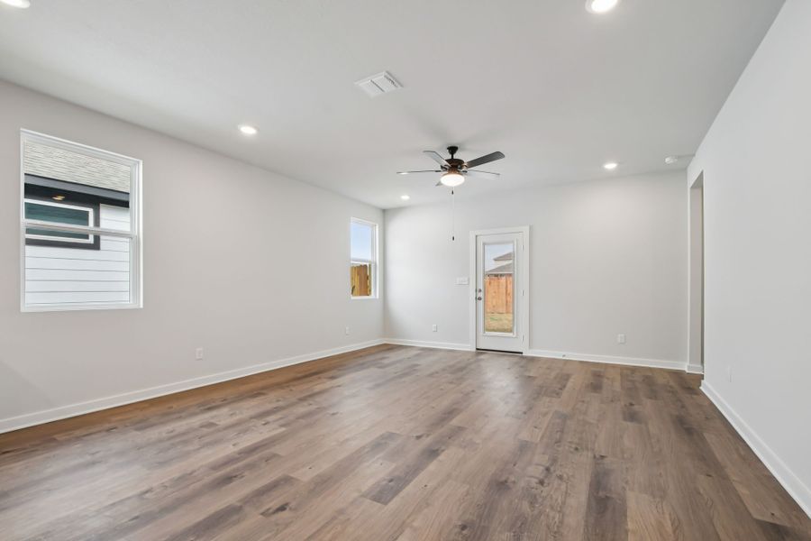 A room with a wood floor and a ceiling fan.