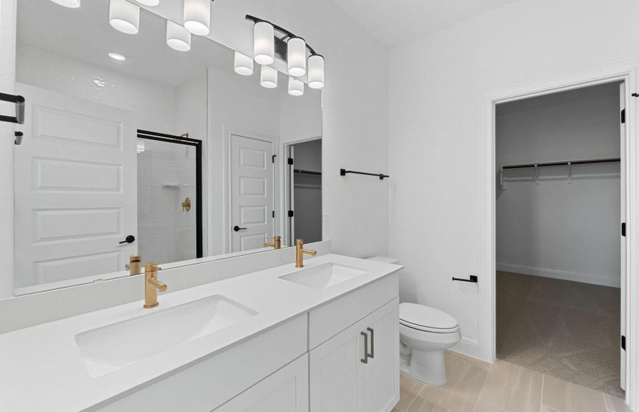 Full bathroom featuring a spacious closet, a shower stall, double vanity, light tile patterned floors, and recessed lighting Full bathroom featuring a spacious closet, a shower stall, double vanity, light tile patterned floors, and recessed lighting