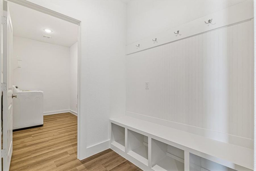 Mudroom featuring washer / dryer and hardwood / wood-style flooring Mudroom featuring washer / dryer and hardwood / wood-style flooring