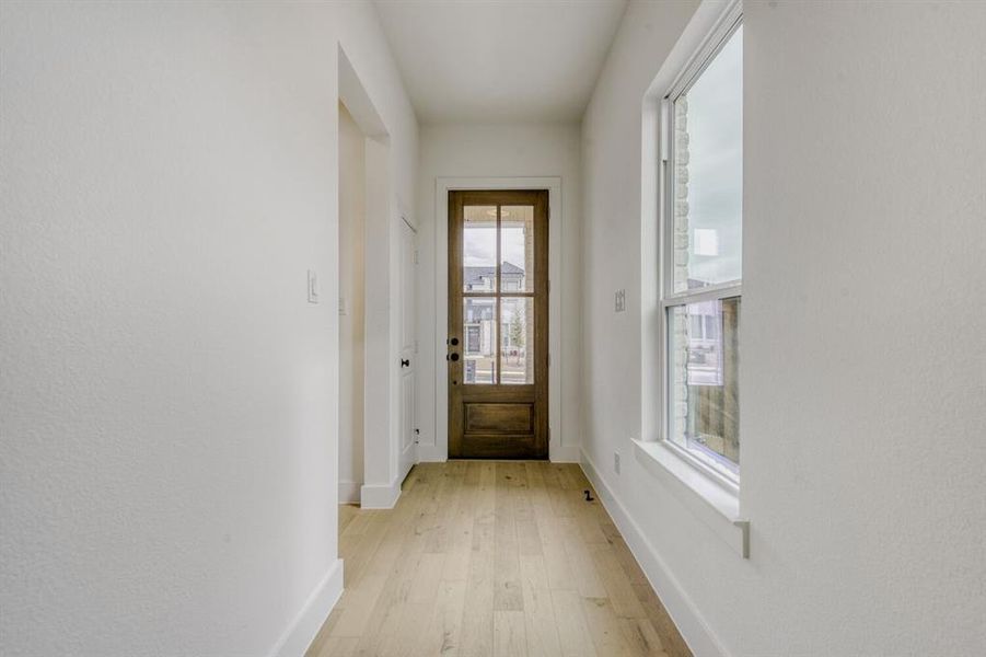 Entryway featuring baseboards and wood finished floors Entryway featuring baseboards and wood finished floors
