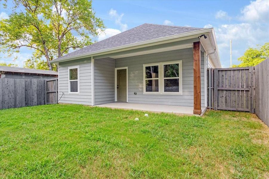 Rear view of house featuring a patio and a yard