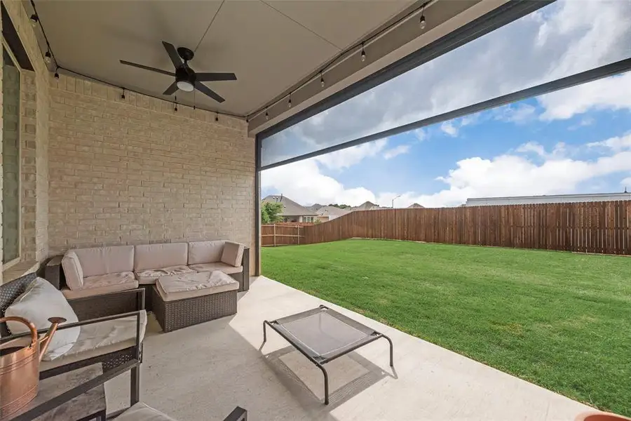 Covered patio featuring a ceiling fan, recessed lighting, and a brick exterior wall