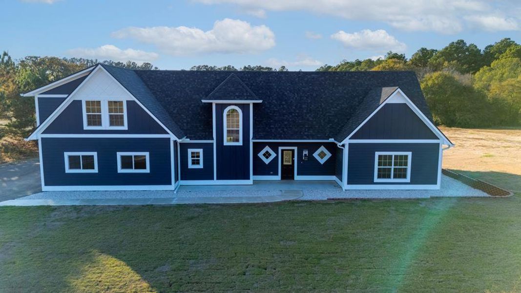 View of front of home featuring a front lawn and a shingled roof