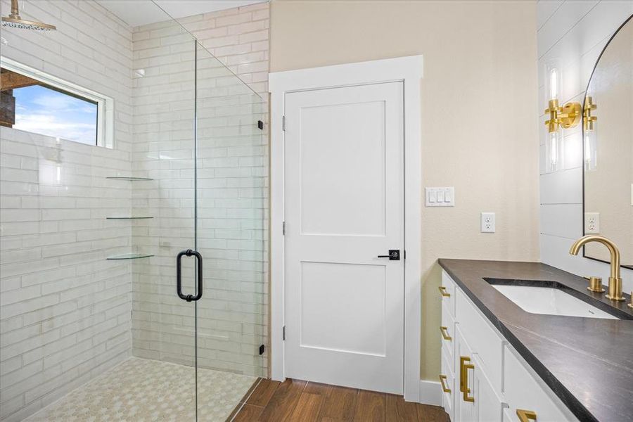 Bathroom with a shower stall, vanity, and dark wood finished floors Bathroom with a shower stall, vanity, and dark wood finished floors